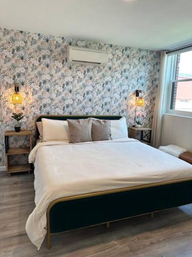 a bedroom with a large white bed with floral wallpaper at Home Haven, Walk to Little Italy & Wooster Square in New Haven