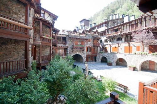 a group of buildings in a courtyard with trees at D2, Bordes d'Arinsal, Duplex Rustico con chimenea, Arinsal , zona Vallnord in Arinsal