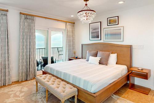 Un dormitorio con una cama grande y una lámpara de araña. en Tortugas De Mar, Unit 303B en Clearwater Beach