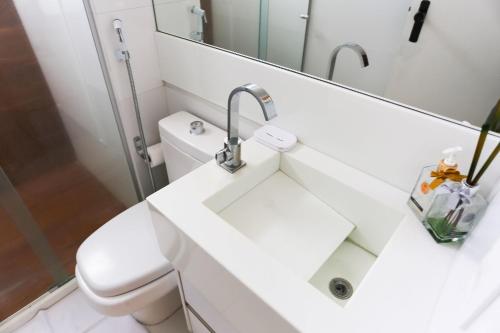 a white bathroom with a sink and a mirror at Ótima Localização - Zona Norte - SEM TAXAS in Recife