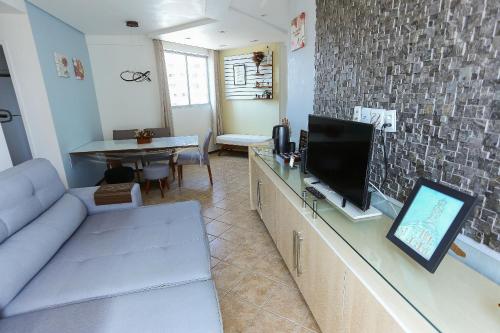 uma sala de estar com um sofá e uma televisão de ecrã plano em Ótima Localização - Zona Norte - SEM TAXAS no Recife