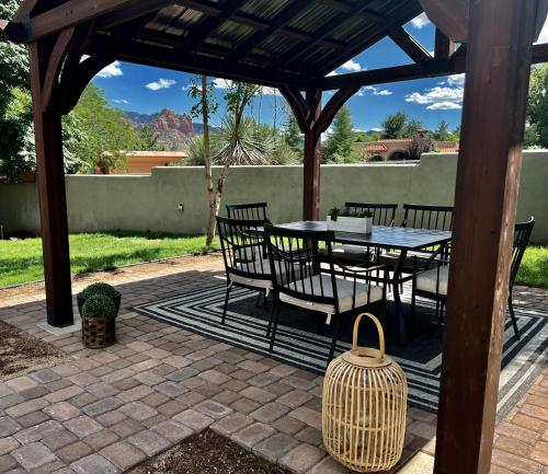 a patio with a table and chairs under a gazebo at Sedona Uptown Gem!Large yard w grass and shade trees! Views!! NEW! BARREL SAUNA!!! Close to trails, walk to Uptown Sedona, restaurants and shopping in Sedona