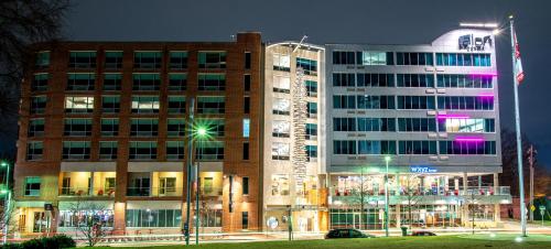 a large building with lights in front of it at Aloft Raleigh in Raleigh