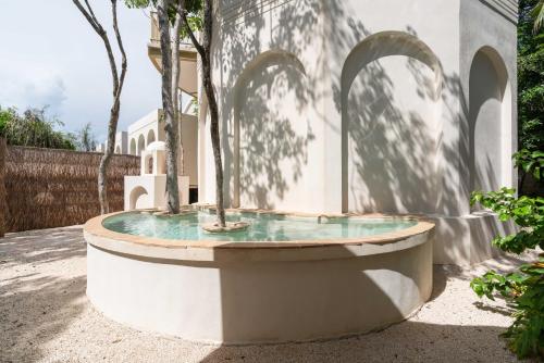 a fountain in the courtyard of a house at Anat Tantric Boutique Hotel in Tulum