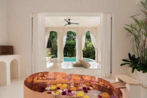 a room with a tub with flowers in it at Anat Tantric Boutique Hotel in Tulum