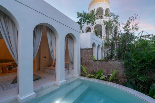 a house with a swimming pool and a building at Anat Tantric Boutique Hotel in Tulum