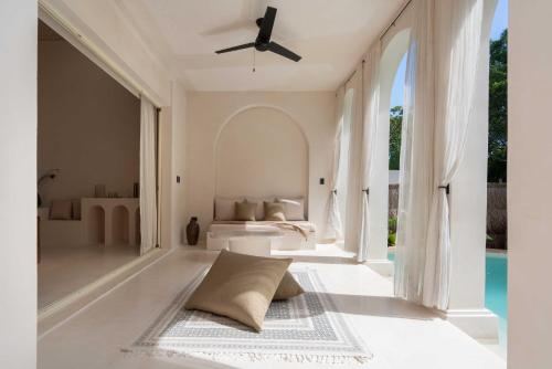a living room with a pool and a ceiling fan at Anat Tantric Boutique Hotel in Tulum