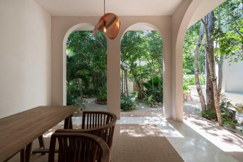 a dining room with a table and chairs and trees at Anat Tantric Boutique Hotel in Tulum