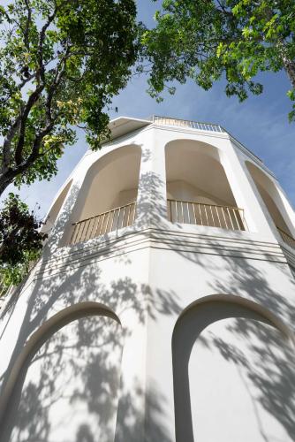 a white building with trees in front of it at Anat Tantric Boutique Hotel in Tulum