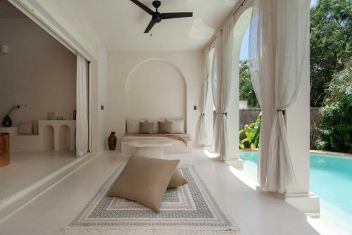 a villa with a swimming pool and a living room at Anat Tantric Boutique Hotel in Tulum
