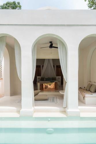 a white house with two arches and a fireplace at Anat Tantric Boutique Hotel in Tulum
