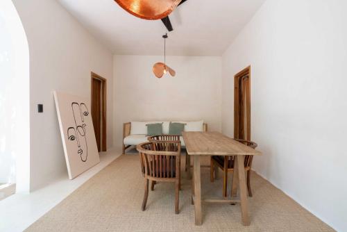 a dining room with a wooden table and chairs at Anat Tantric Boutique Hotel in Tulum