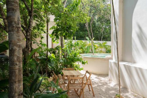 a patio with a table and chairs and a bath tub at Anat Tantric Boutique Hotel in Tulum