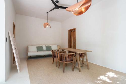 a dining room with a table and chairs and a couch at Anat Tantric Boutique Hotel in Tulum