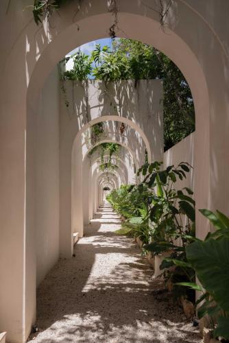 an archway with plants on the side of a building at Anat Tantric Boutique Hotel in Tulum