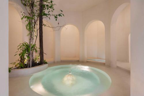a bathroom with a tub with a tree in it at Anat Tantric Boutique Hotel in Tulum