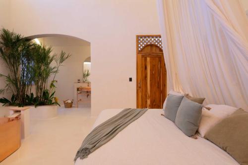 a bedroom with a white bed with a canopy at Anat Tantric Boutique Hotel in Tulum
