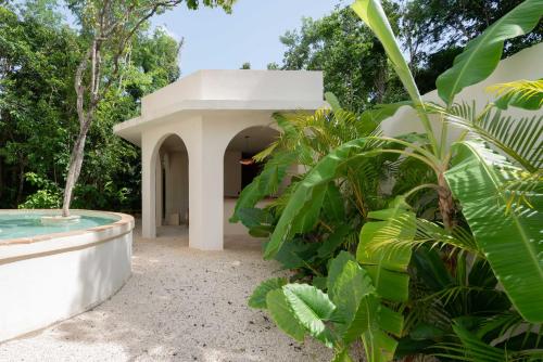 a house with a swimming pool in a garden at Anat Tantric Boutique Hotel in Tulum