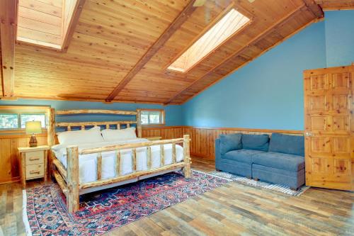 een slaapkamer met een bed en een blauwe bank bij Dreamy Show Low Cabin with Deck on Over 2 Acres! in Show Low