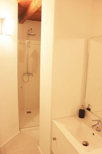 a white bathroom with a shower and a sink at Casa Las Alacenas, Bubión (La Alpujarra, Granada) in Bubión