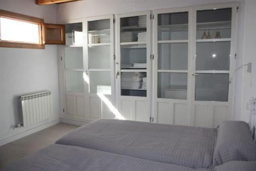 a bedroom with white cabinets and a bed in it at Casa Las Alacenas, Bubión (La Alpujarra, Granada) in Bubión