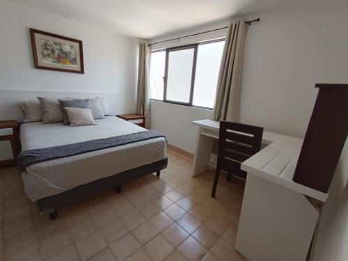 sypialnia z łóżkiem, biurkiem i oknem w obiekcie Casa Arena w mieście Casa Blanca La Corregidora