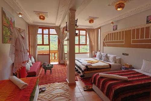 a bedroom with two beds and a living room with a couch at Riad Dar Omar in Imlil