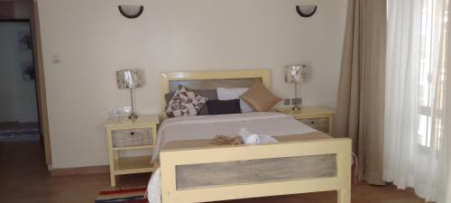 a bedroom with a bed with two night stands at Shawmut suites in Nakuru