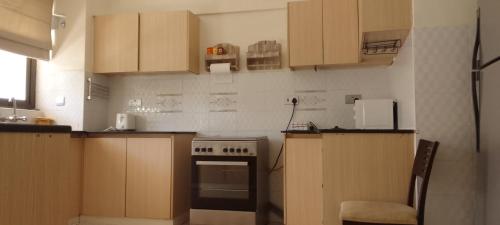 a kitchen with wooden cabinets and a stove top oven at Shawmut suites in Nakuru