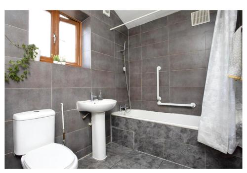 倫敦的住宿－The Leyton Oasis，浴室配有卫生间、盥洗盆和浴缸。