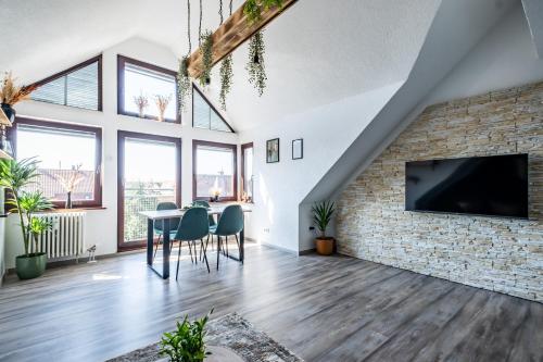 a living room with a stone wall and a flat screen tv at Nature Terminal Apartment - unterwegs zuhause in Steinenbronn