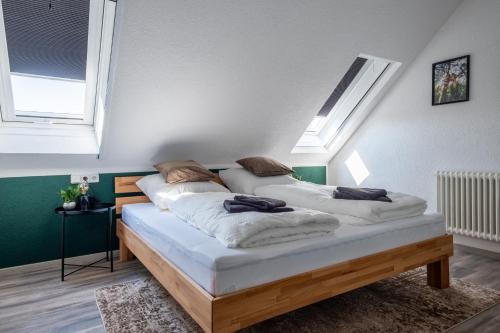 two beds in a room with two windows at Nature Terminal Apartment - unterwegs zuhause in Steinenbronn