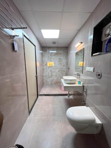 a bathroom with a toilet and a sink at Modern villa 4BR, Lawn & Mini Pool in Belagavi in Shāhāpur