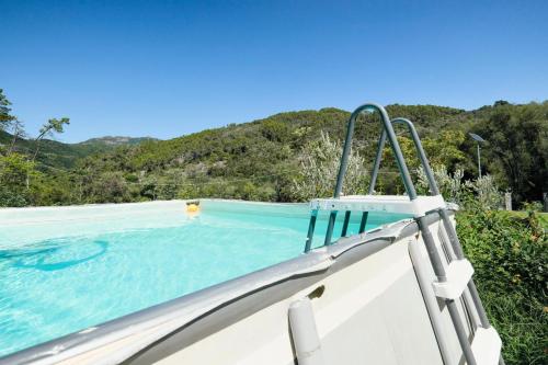 a person in a swimming pool next to a boat at VILLA EMILY in Framura