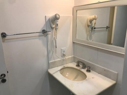 a bathroom with a sink and a mirror at COPACABANA NA QUADRA DA PRAIA - 2 Quartos e Sala in Rio de Janeiro