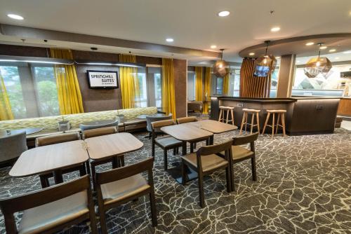 ein Restaurant mit Tischen und Stühlen und eine Bar in der Unterkunft SpringHill Suites Columbus Airport Gahanna in Gahanna