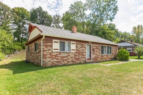une petite maison en brique avec une pelouse dans l'établissement Cozy Retreat in Cincinnati home, à Cincinnati