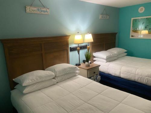 2 letti in una camera d'albergo con pareti blu di Oceanfront Oasis a Myrtle Beach