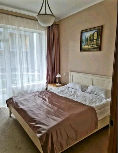a bedroom with a large bed and a large window at Turaidas apartment Jurmala in Jūrmala