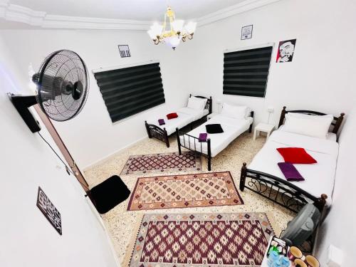 ein Wohnzimmer mit 2 Sofas und einem Ventilator in der Unterkunft Desert Moon in Wadi Musa