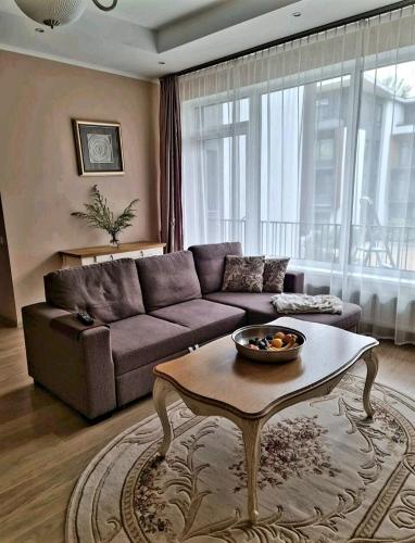 a living room with a couch and a coffee table at Turaidas apartment Jurmala in Jūrmala