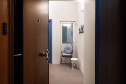 une porte donnant sur un couloir avec une chaise bleue dans l'établissement Maison Ammiragli Vatican Rooms, à Rome