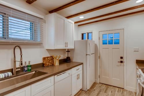 a kitchen with white cabinets and a refrigerator at The Urban Cowboy Bunk House in Phoenix