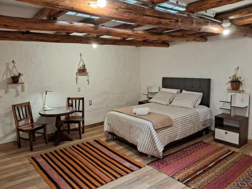 een slaapkamer met een bed en een tafel en stoelen bij KOSKO Casa Hotel in Cuzco