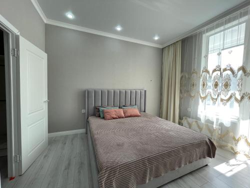 een slaapkamer met een bed met roze kussens erop bij Sat City Deluxe in Astana