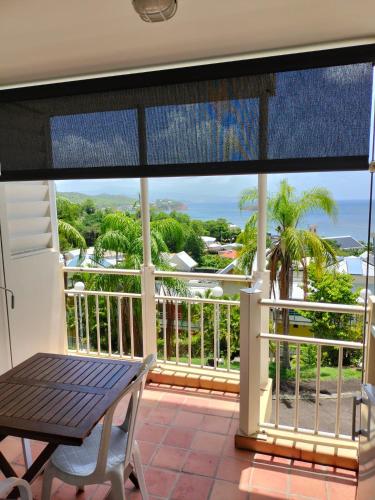 a balcony with a table and a view of the ocean at Appartements vue mer - Résidence de la baie - Tartane in La Trinité