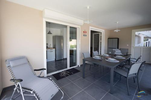 a dining room with a table and chairs at L'Anse Plage appartement 2 chambres avec spa à 200 m de la plage, jardin Privé et Parking in Les Trois-Îlets