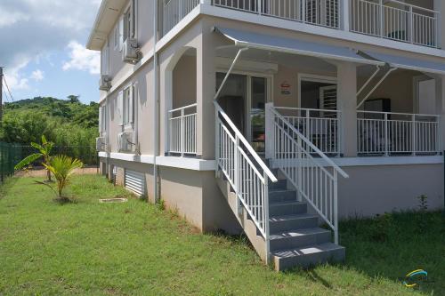 a house with a staircase leading to the front of it at L'Anse Plage appartement 2 chambres avec spa à 200 m de la plage, jardin Privé et Parking in Les Trois-Îlets