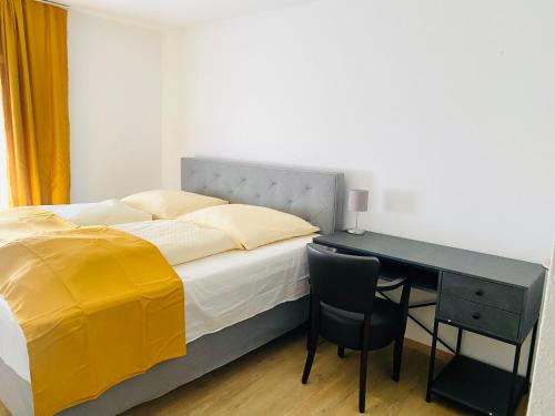 Hotel SuvaNa : غرفة نوم بسرير ومكتب مع بطانية صفراء