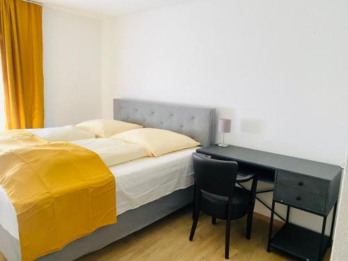 a bedroom with a bed and a desk with a yellow blanket at Hotel SuvaNa 